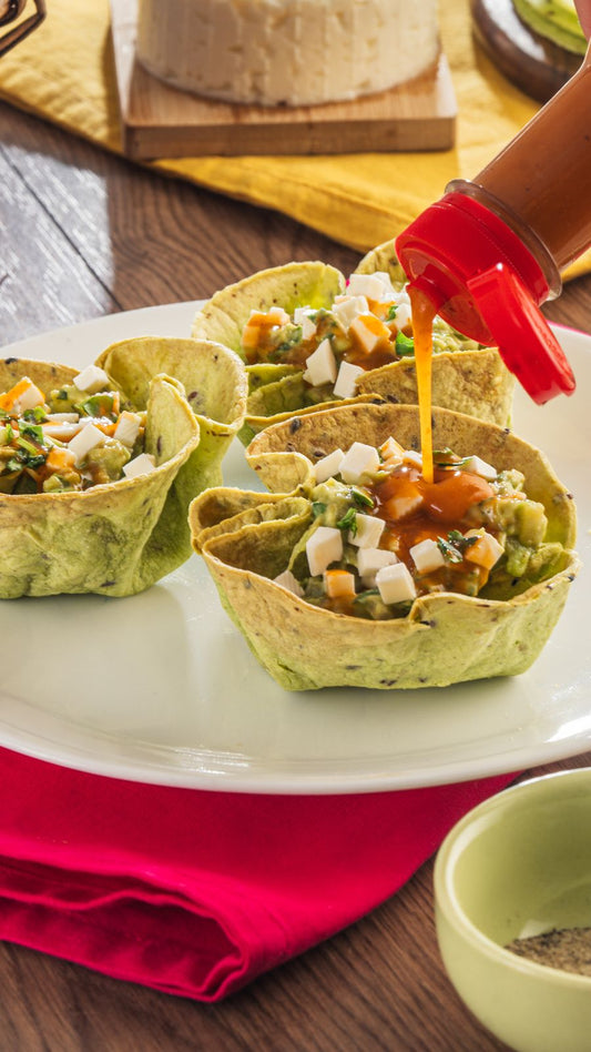 Un plato de cazuelitas de guacamole bañadas con Salsa México Lindo Habanero Rojo