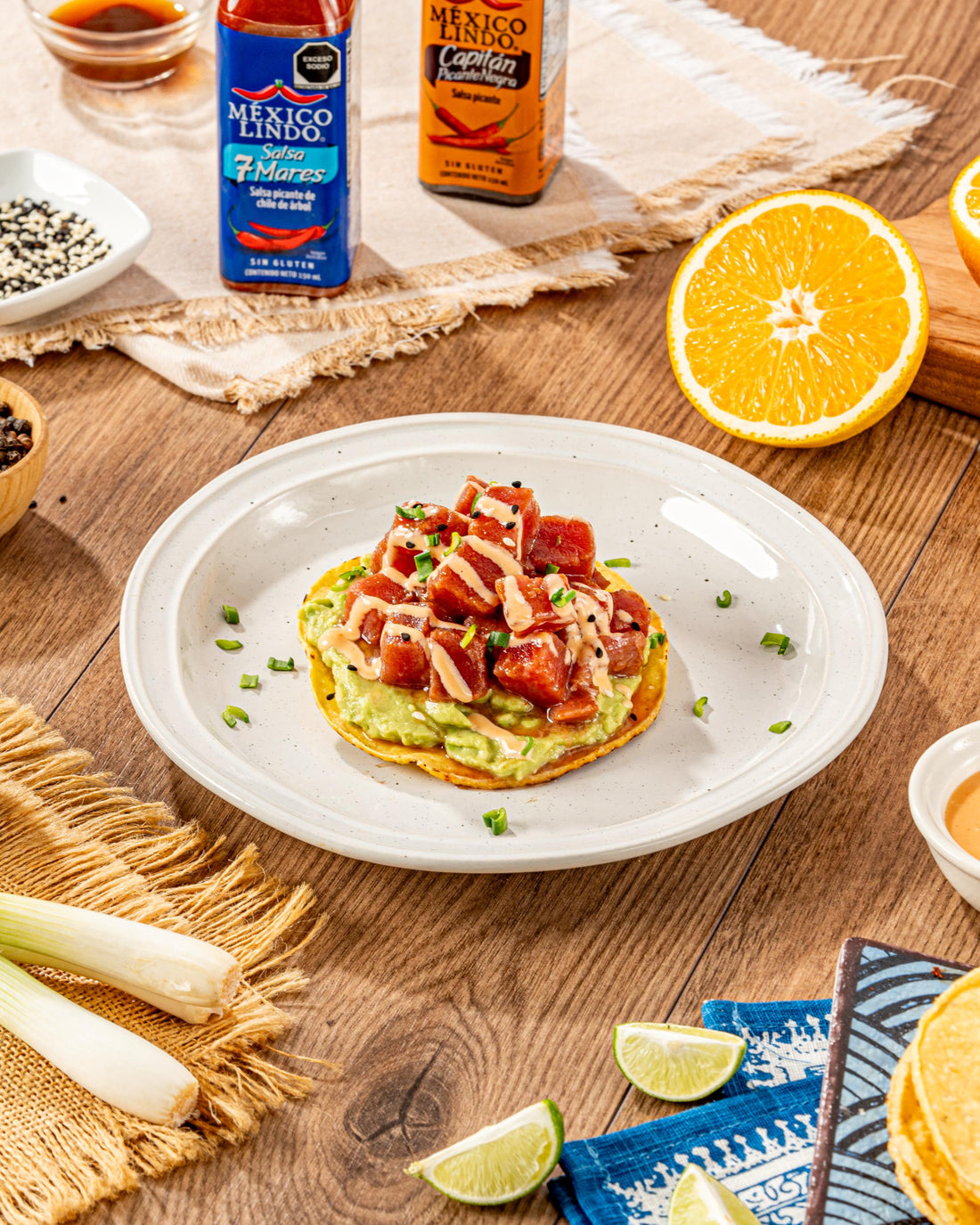 Deliciso Tostada de atún, servida en una tostada de maíz con una cama de guacamole, salseado con salsa mil islas, Salsa México Lindo Capitán Picante Negra®️